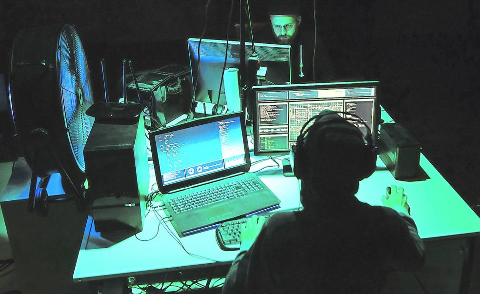 Dos expertos en informática trabajan con varias pantallas.