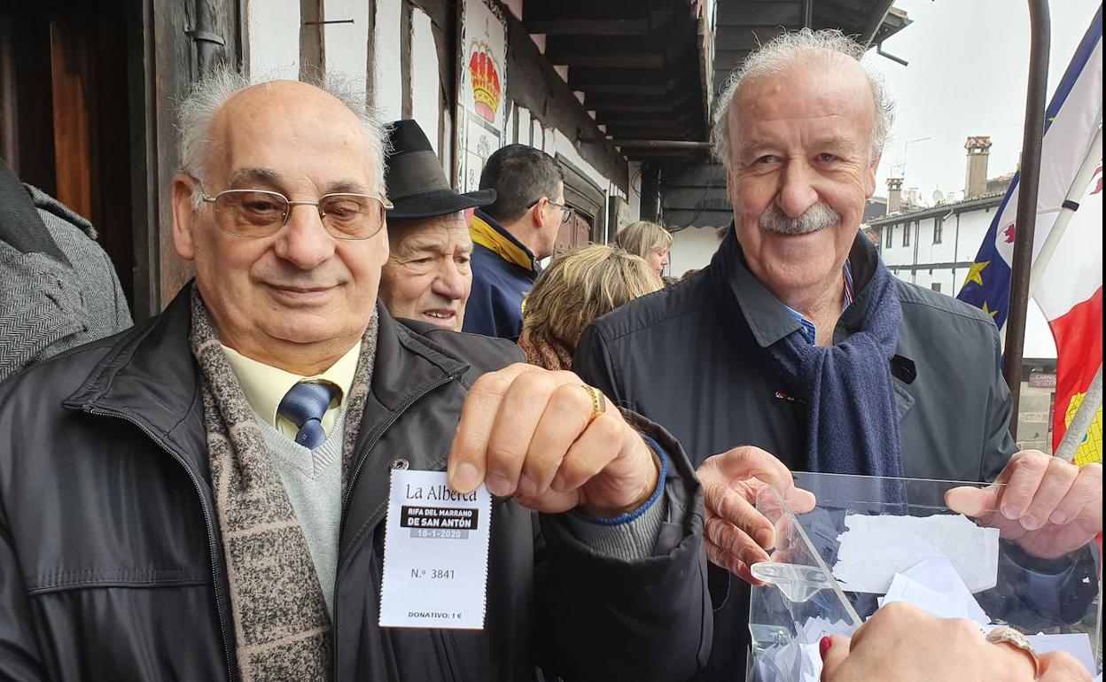 El hijo de Leandro 'El Colorín' y Vicente del Bosque muestran la papeleta ganadora.