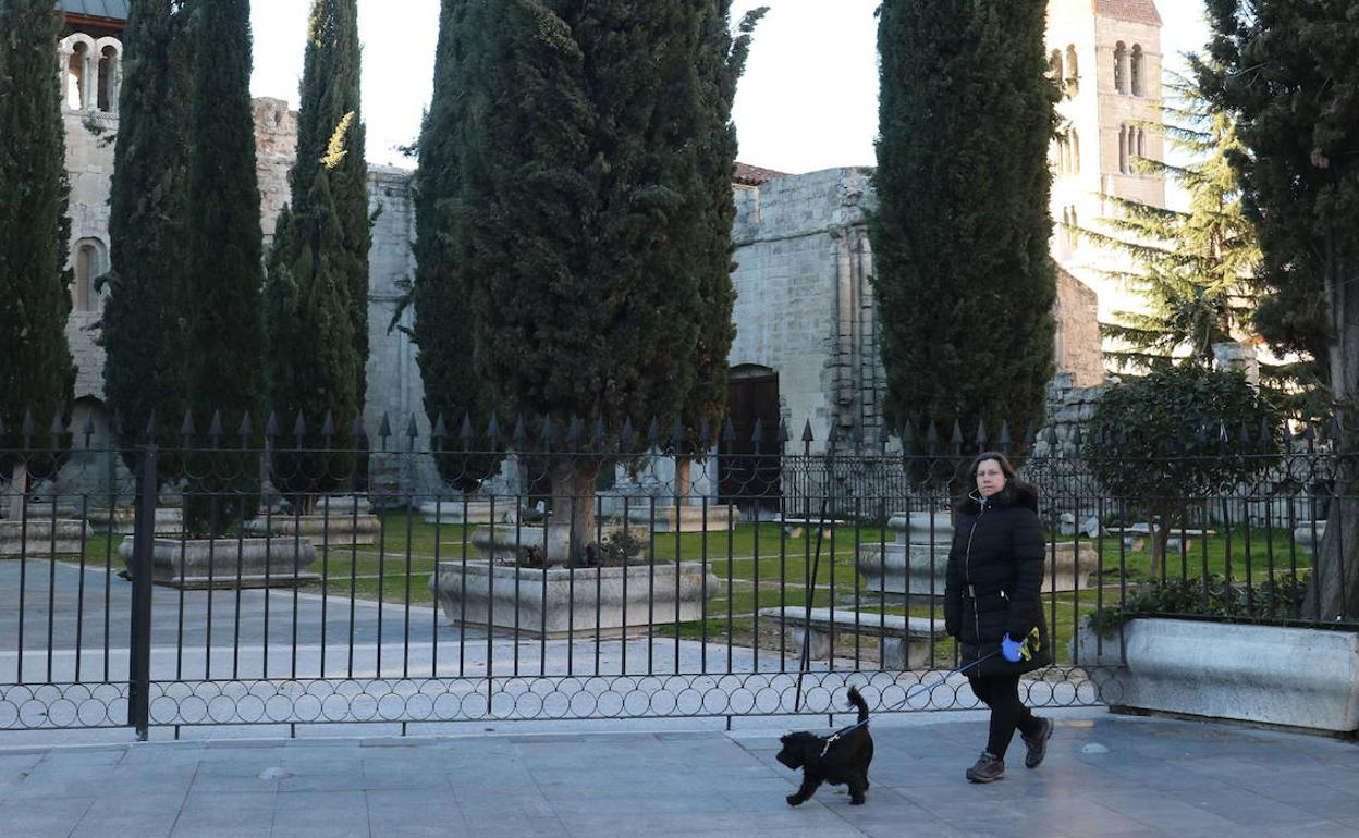 Una mujer pasea junto al Patio de los Cipreses de la catedral.