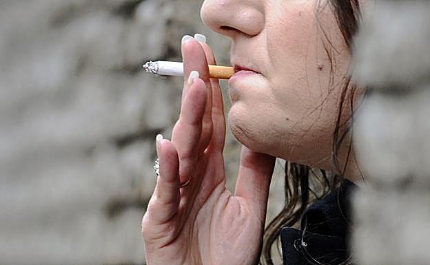 Resultado de una prueba en un paciente con cáncer de pulmón y, sobre estas líneas, una mujer fumadora. 