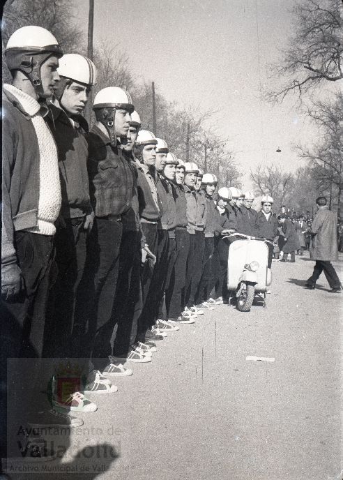 El domingo 19 de enero de 1958, veinte mil personas presenciaron la prueba que se celebró en el paseo alto de las Moreras | La prueba consistió en formar una barrera humana sobre una moto Vespa con diez y siete hombres abordo y así recorrer más de quinientos metros, batiendo el récord mundial que los ingleses habían establecido días antes | La 'Vespa' era conducida por Virgilio Collantes, el gran héroe del día