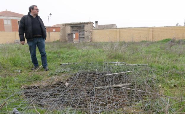 El alcalde de Villalar de los Comuneros, Luis Alonso Laguna, muestra un agujero tapado con alambrada en el solar de la Fundación.