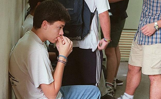 Un joven se muerde las uñas antes de un examen.