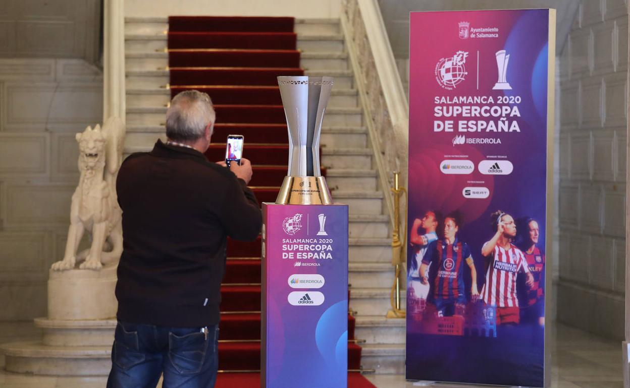 Una persona fotografía la copa instalada en el zaguán del Ayuntamiento de Salamanca. 
