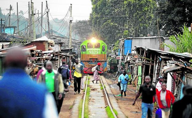 Una mujer cruza las vías en Kibera, en el extrarradio de Nairobi, la capital keniata.