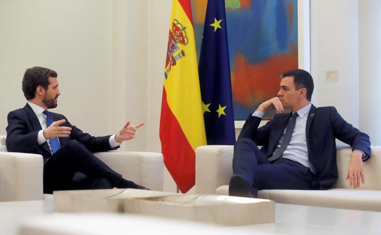 El presidente del Gobierno, Pedro Sánchez, conversa con el líder del Partido Popular, Pablo Casado.