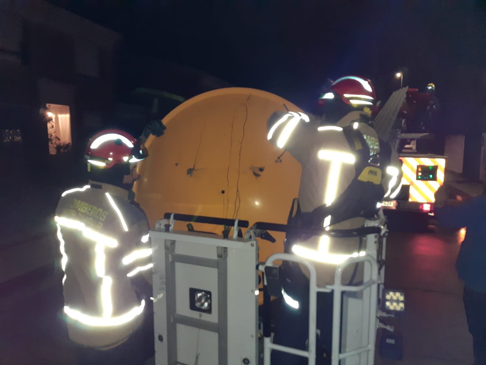 Imagen principal - Los servicios de emergencias del 112 trabajan en la retirada de una antena parabóiica y un árbol en Boecillo (Valladolid).