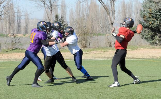 El quaterback se dispone a realizar un pase sobre la carrera de un compañero. 