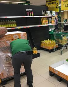 Imagen secundaria 2 - El espacio destinado a las cajas de leche, vacío en un gran superficie de la capital vallisoletana. Abajo a la izquierda, el estante del papel higiénico, casi vacío, en un supermercado del polígono de Argales y Varios operarios reabastecen el aceite en otro supermercado del barrio de Parquesol. 