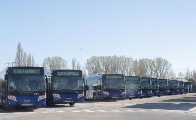 Imagen principal - Los autobuses de Auvasa, parados en sus cocheras: un camarero recoge la terraza del Lion D'Or y un comercio cerrado en el centro.