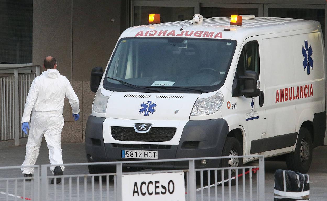 Un sanitario con un buzo de protección y una ambulancia en el Hospital General de Segovia. 