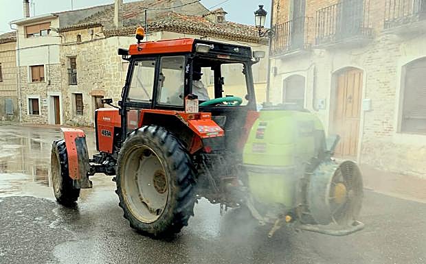 Un tractor limpia de virus una calle de Torquemada. 