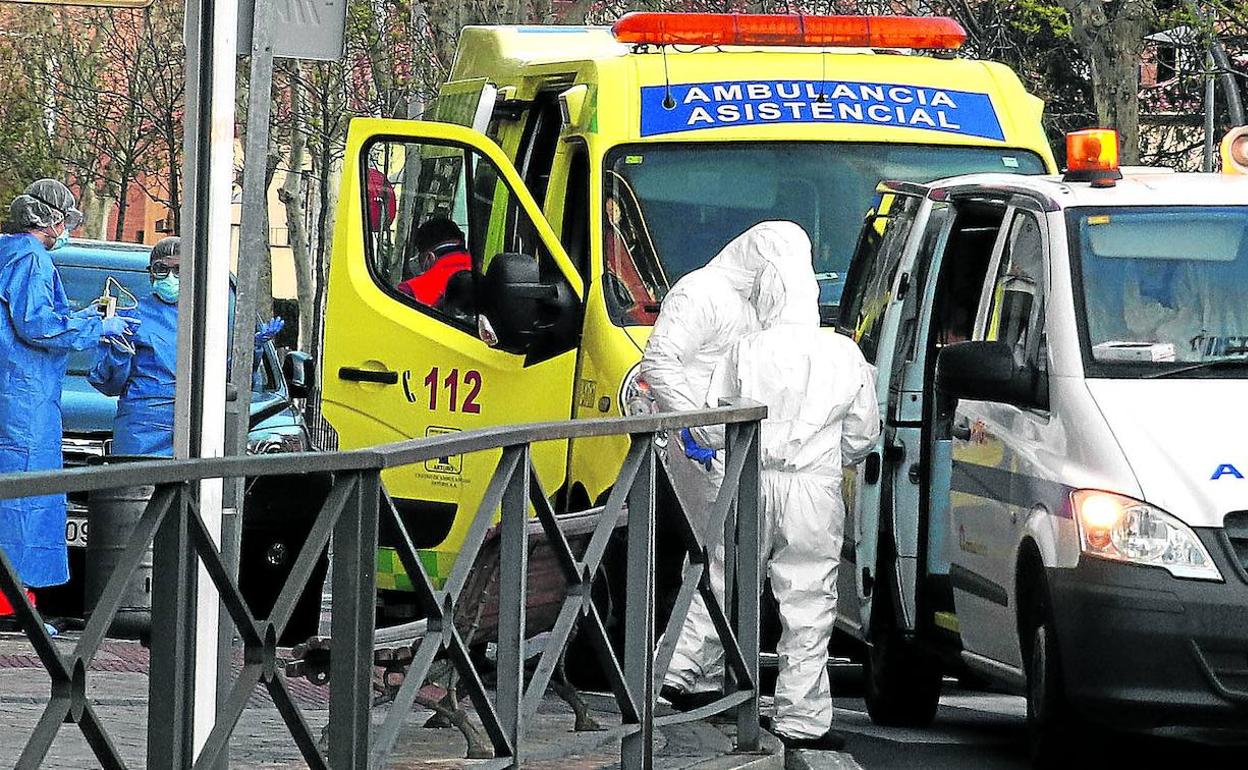 Dos ambulancias y personal asistencial con el buzo de protección atienden un aviso en la ciudad de Segovia, ayer. 