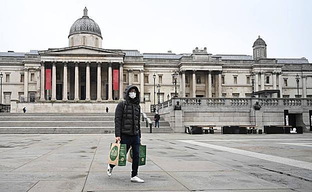 Un ciudadano cruza un desértico Trafalgar Square, en Lonfres.