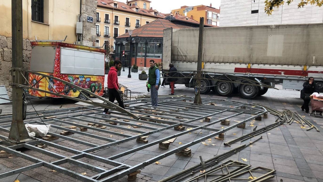 Dos feriantes desmontan una atracción en la plaza de la Rinconada. 