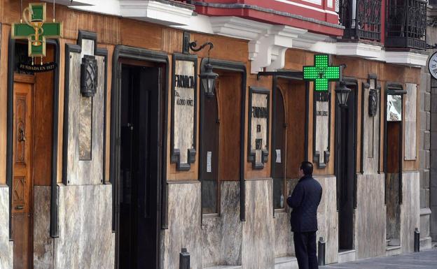 Un hombre, a la puerta de una farmacia en León.