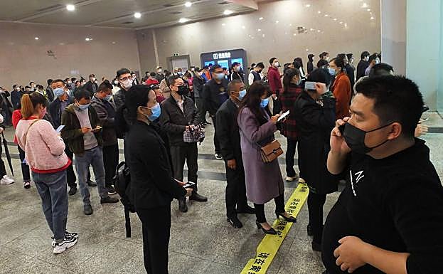 Decenas de personas, en una estación de trenes de China.