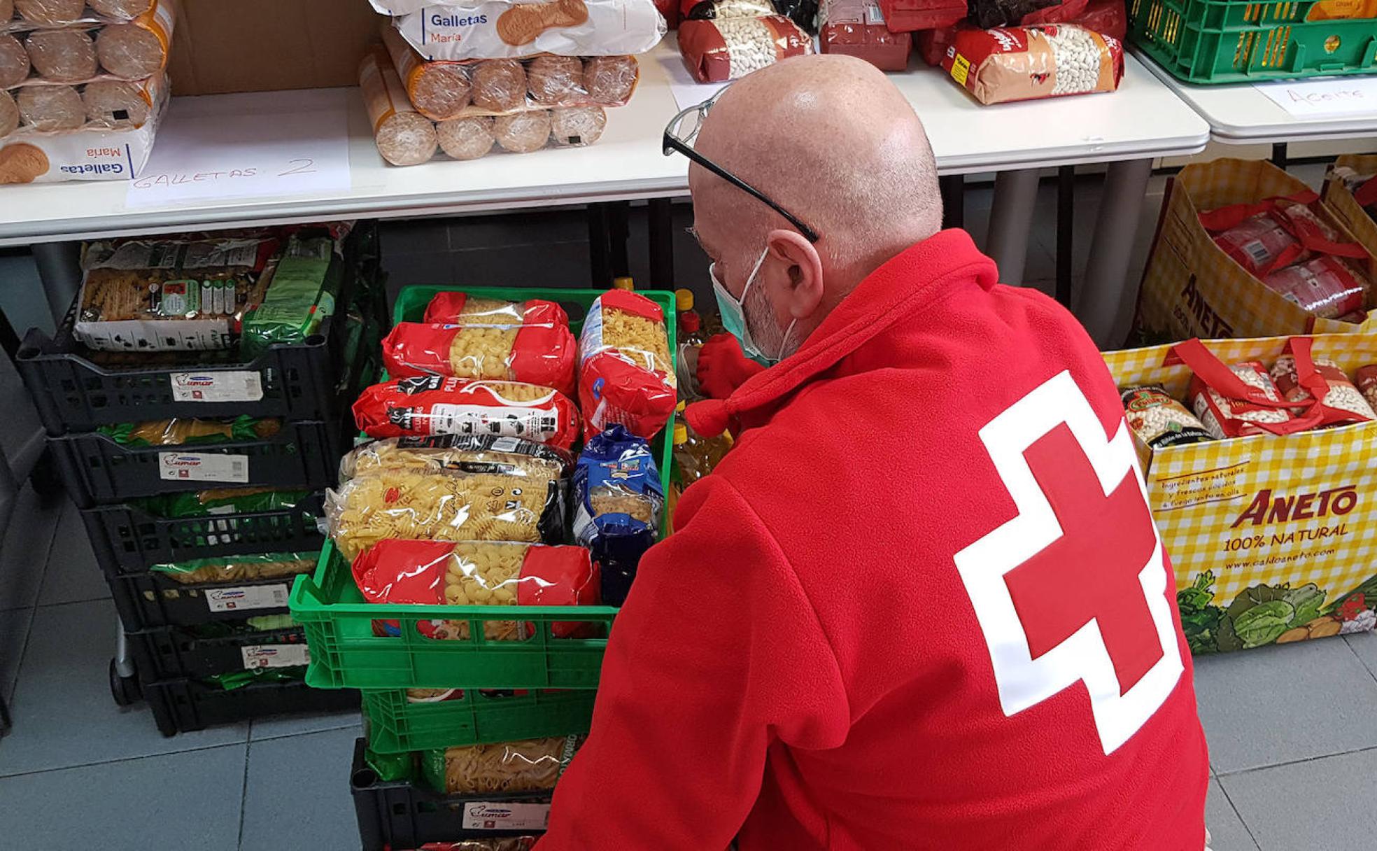 Recogida de alimentos por paete de un voluntario de Cruz Roja en Segovia para su posterior reparto. 