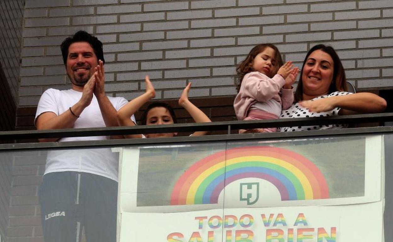 Una familia aplauda desde el balcón de su casa en Valladolid.