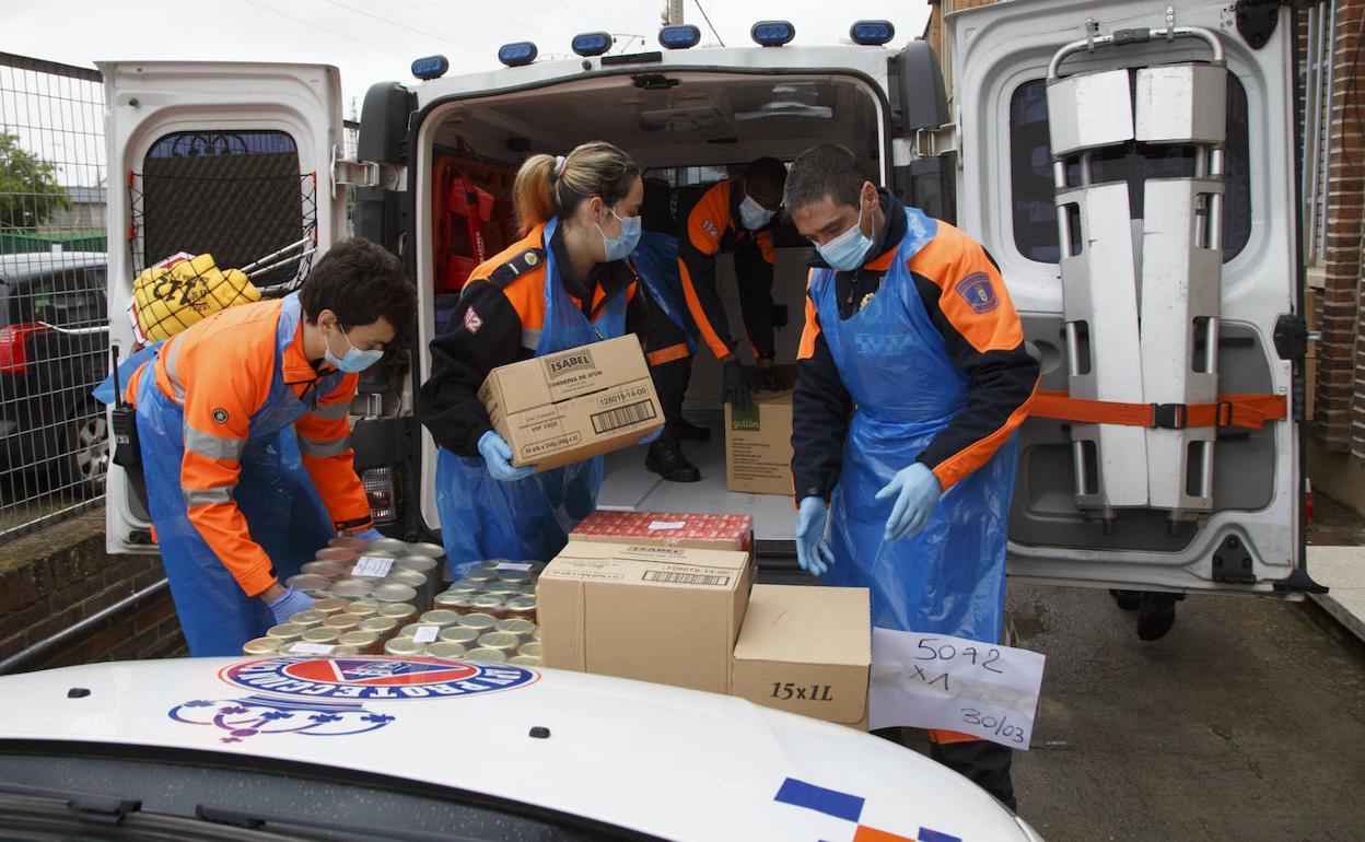 Voluntarios de Protección Civil llenan un furgón con víveres del Banco de Alimentos. 