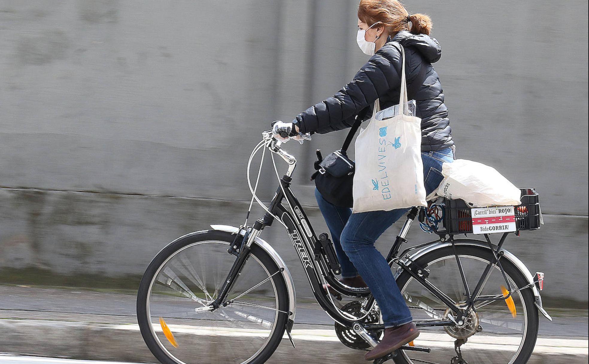 Una mujer se mueve en bicicleta ayer en Valladolid para hacer la compra. 