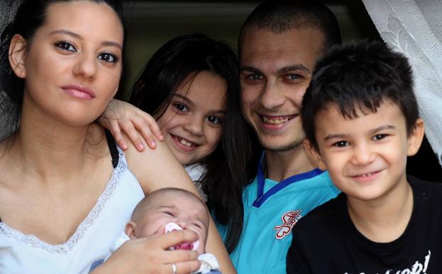 Manu y su familia, asomados a la ventana de su casa. 