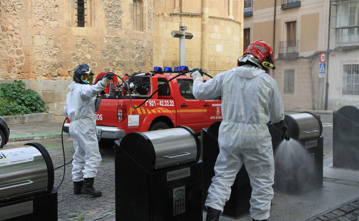 Un equipo de bomberos desinfectacontenedores de basura. Tanarro