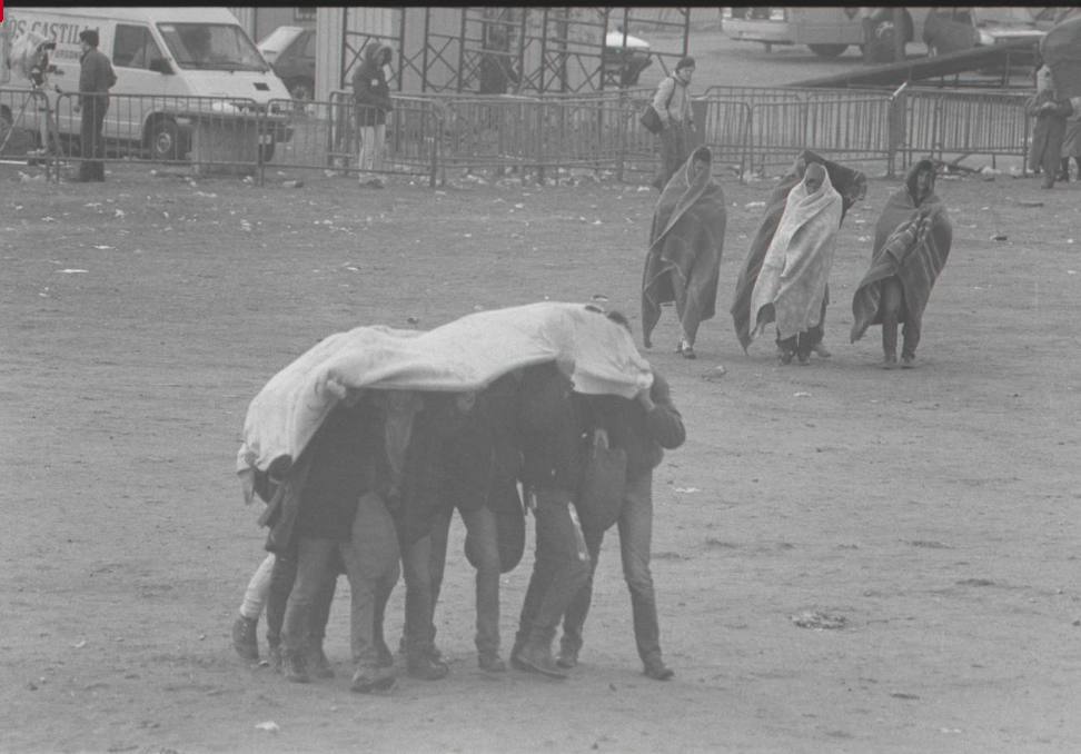 1986. Asistentes a la fiesta se cubren con mantas para combatir el frío.