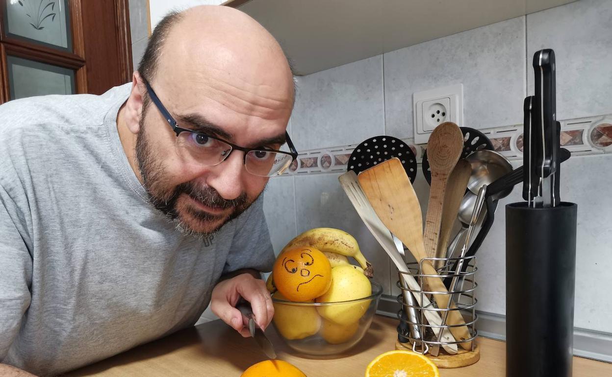 Rafa se dispone a cortar unas naranjas, en su cocina.