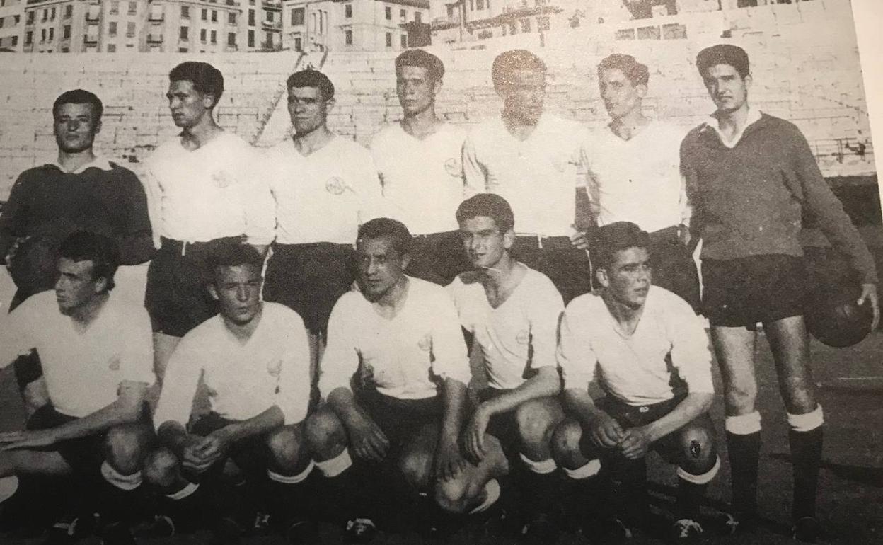 Blanco, agachado, tercero por la derecha. 