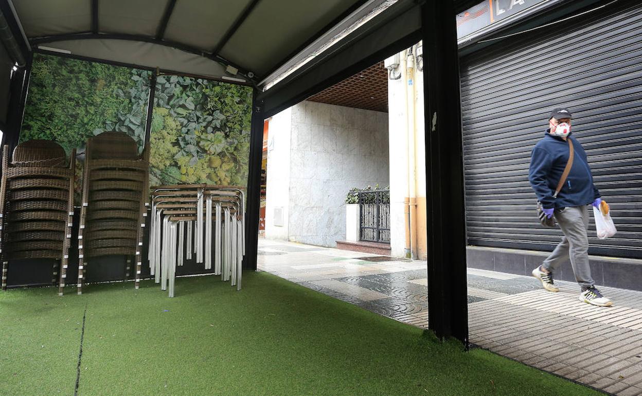 Un hombre camina con una mascarilla junto a una terraza de la avenida República Argentina. 