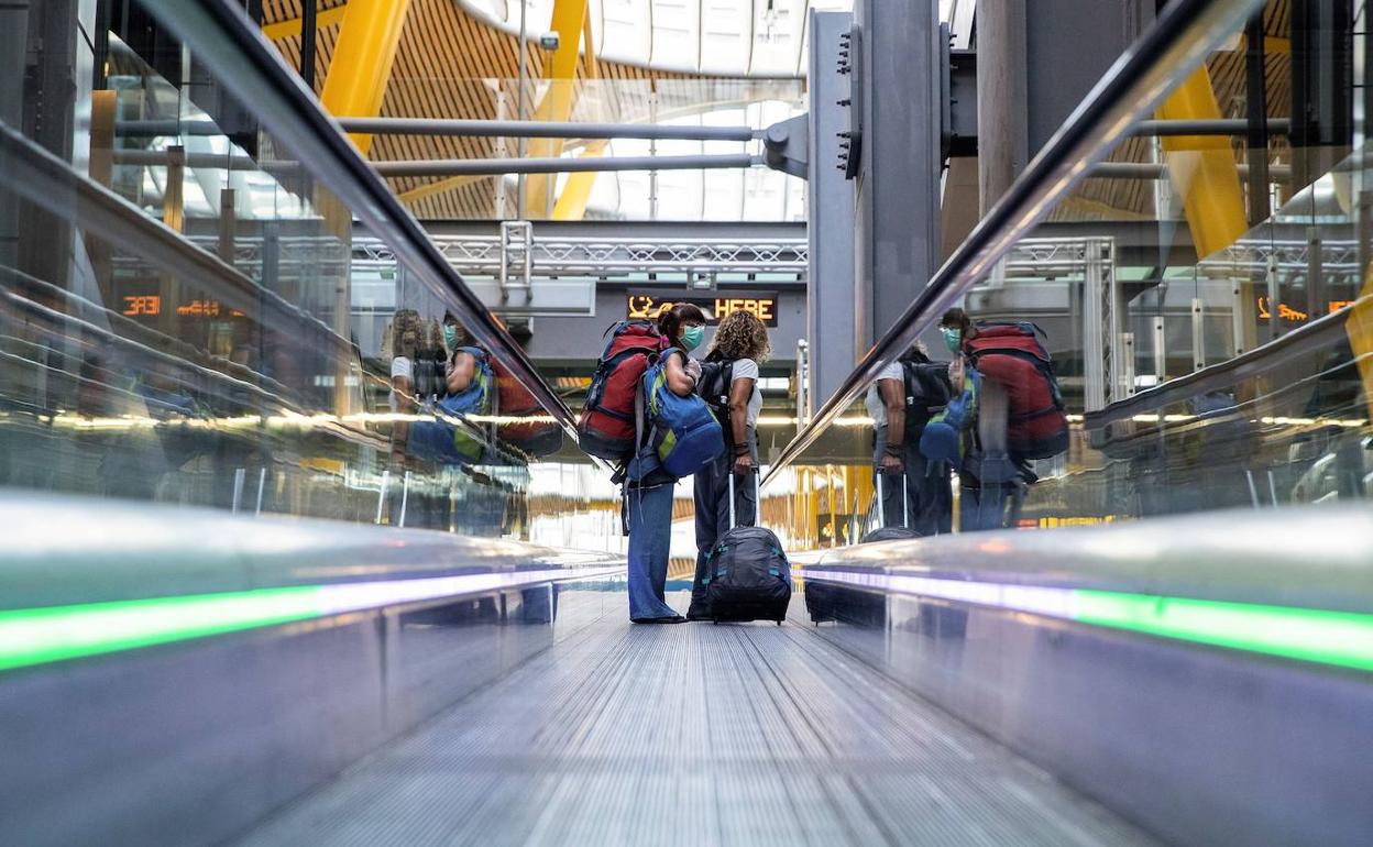 Dos viajeros en un prácticamente vacío aeropuerto de Adolfo Suárez.