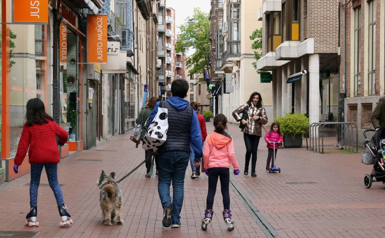 Varias familias caminan por la calle Teresa Gil. 