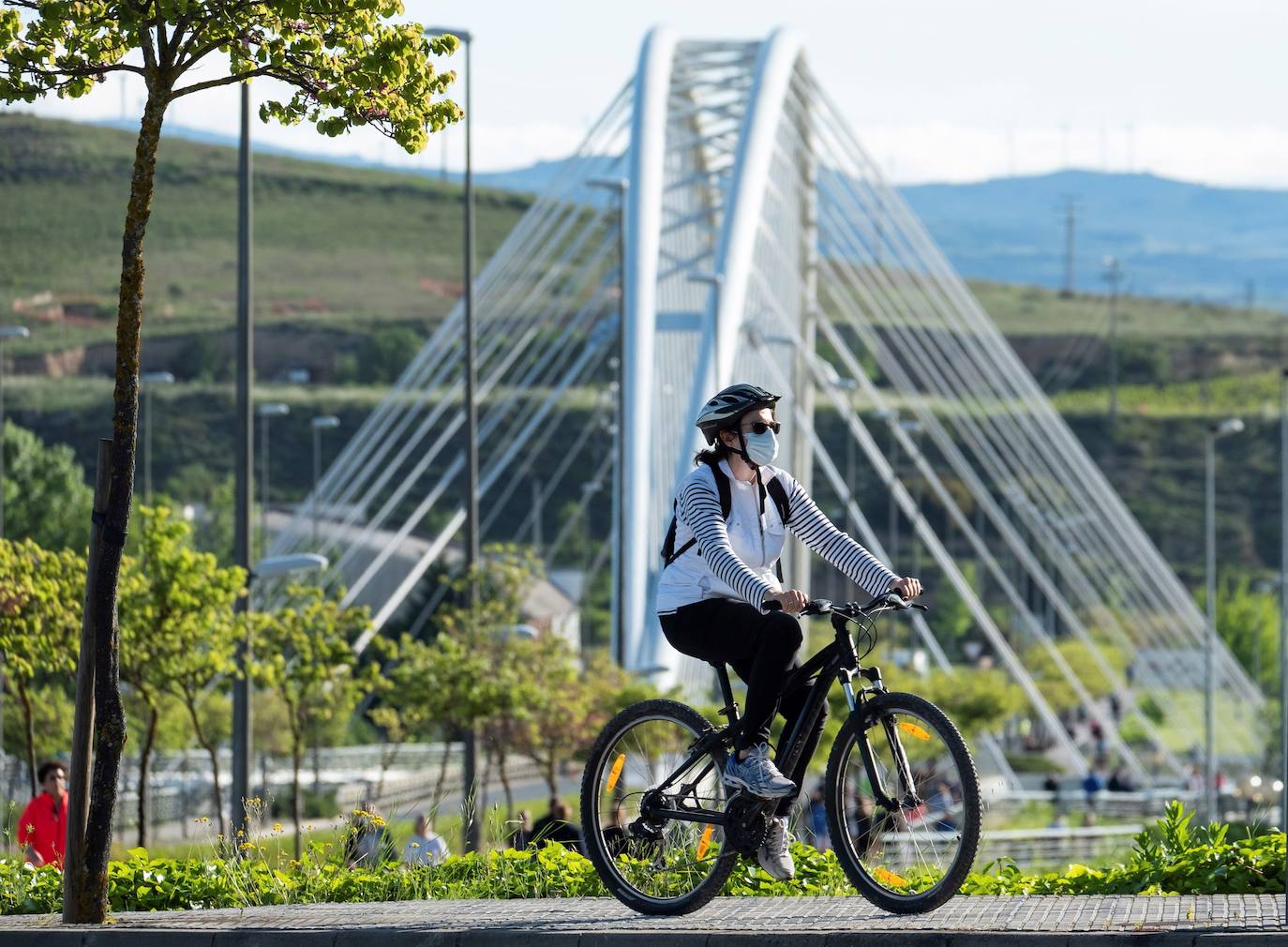 Una mujer pasea con su bicicleta en las calles de Logroño.