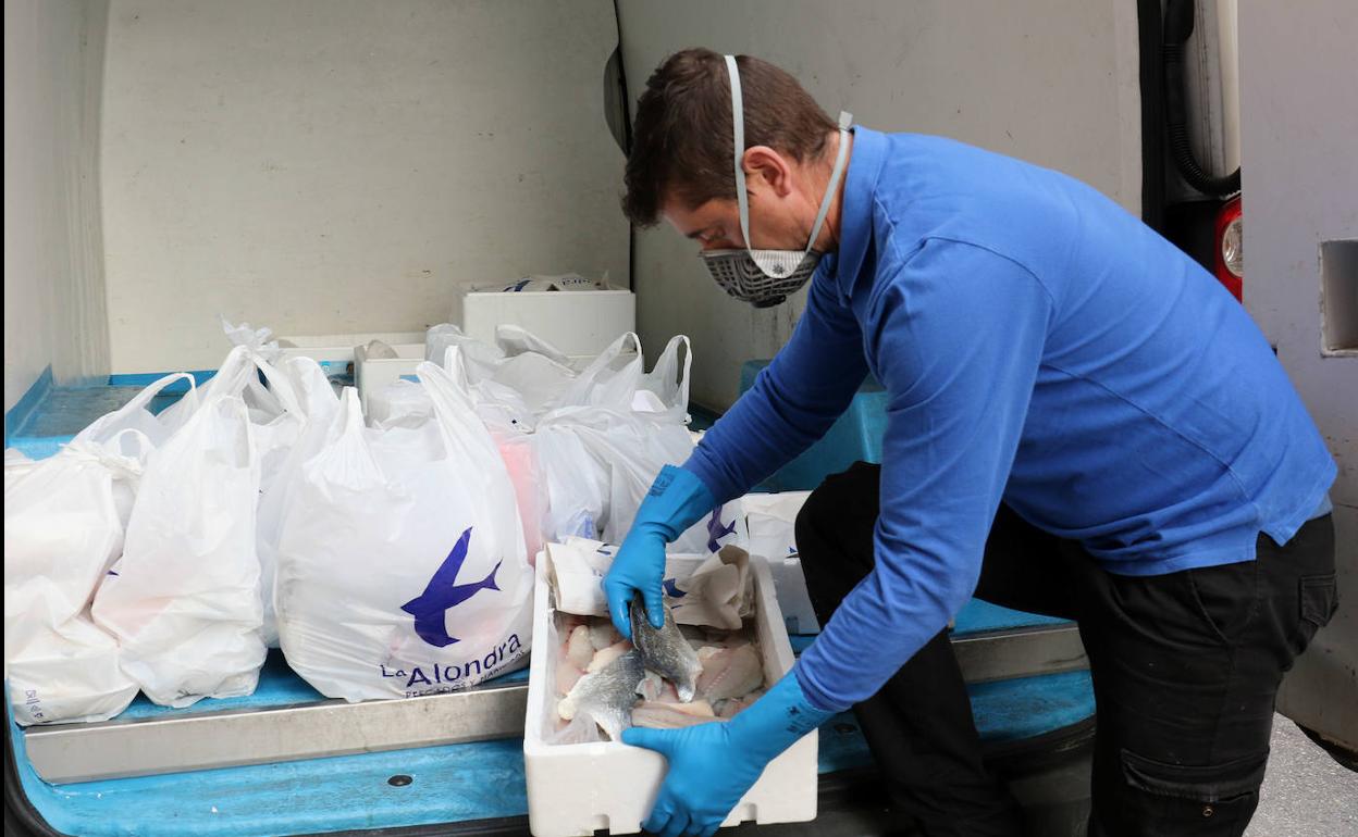 Un repartidor de La Alondra examina el pescado antes de cargarlo.