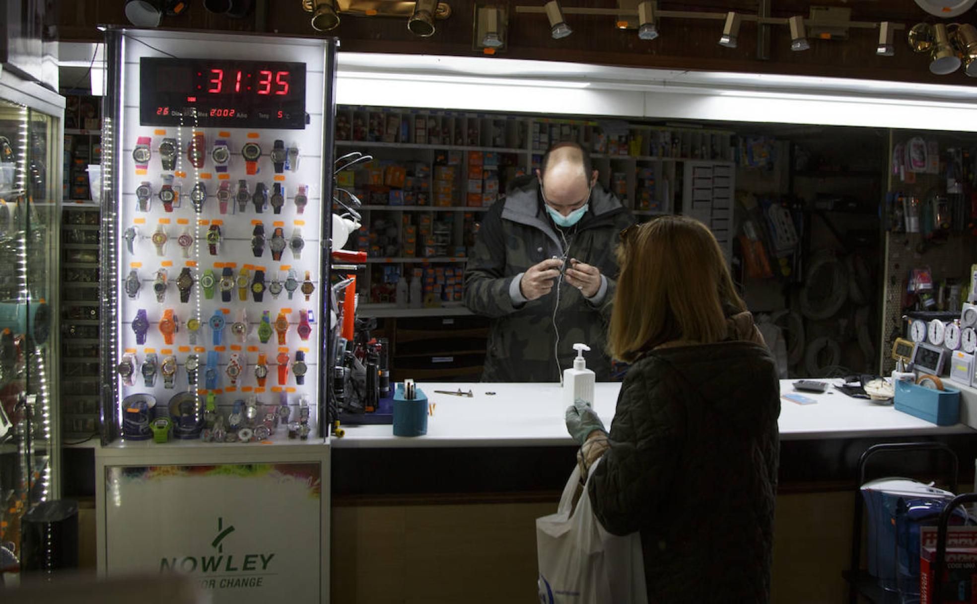 Jorge de Prado atiende a una cliente, en el interior de su establecimiento Electro Bazar Radio Valdeprado, en Valladolid. 