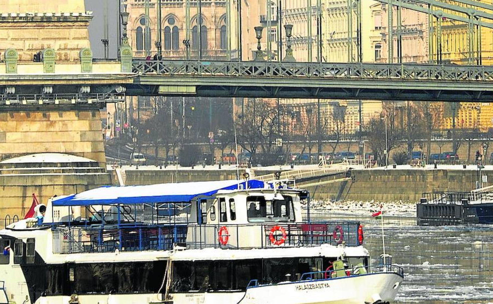 Barco turístico por el Danubio en Budapest, bajo el Puente de las Cadenas y con el Parlamento al fondo. 