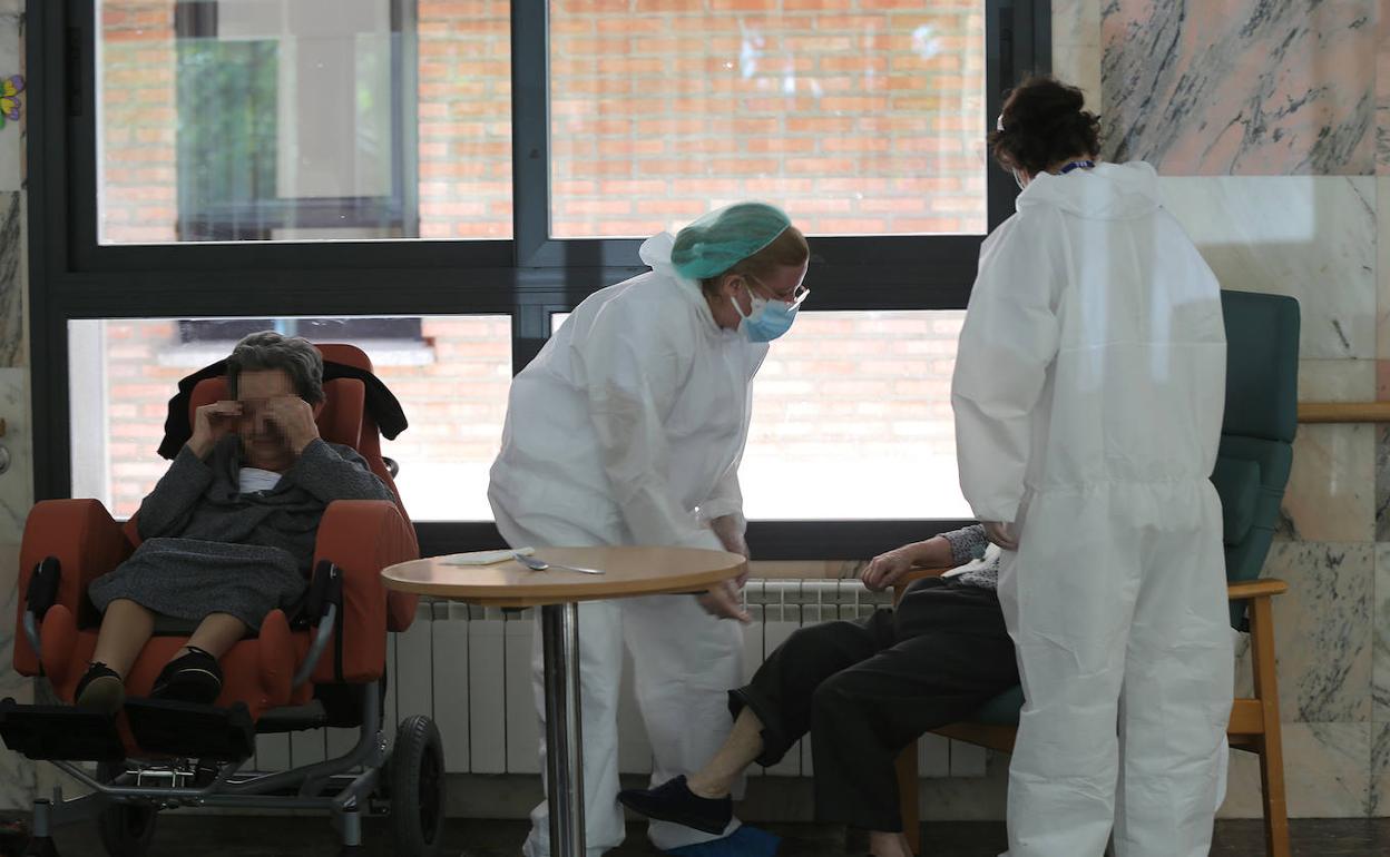 Dos cuidadoras atienden a residentes en la residencia Cardenal Marcelo. 