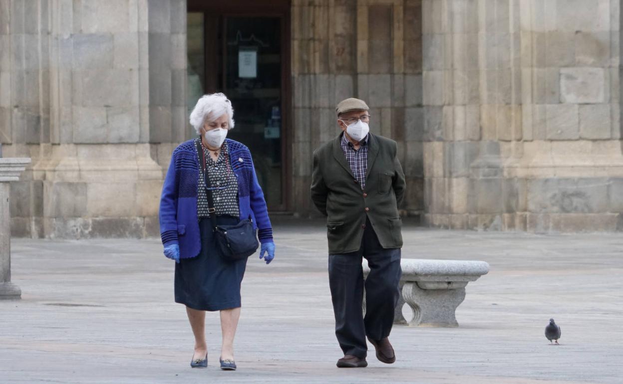 Dos personas paseando por la Plaza Mayor salmantina con sus mas