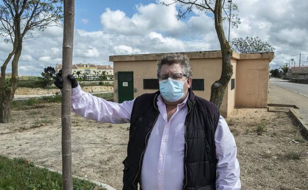 El alcalde de Peñaflor de Hornija, Juan Antonio Gutiérrez, con los depósitos de agua detrás.