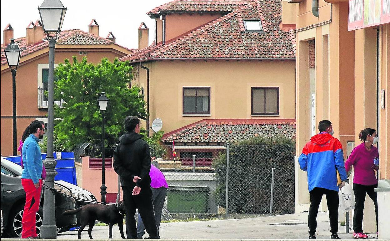 Varias personas, ayer, delante de un comercio en la localidad de Torrecaballeros. 