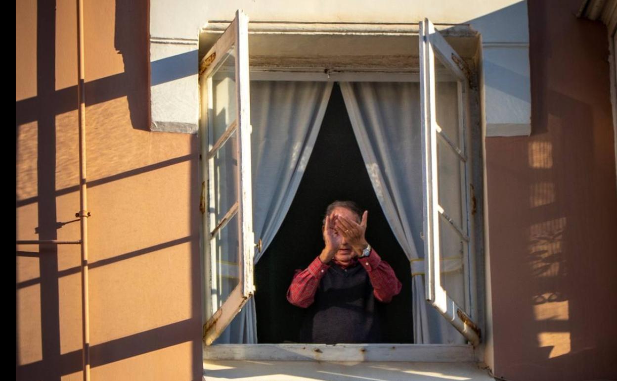 Un hombre aplaude desde su ventana en Santander. 