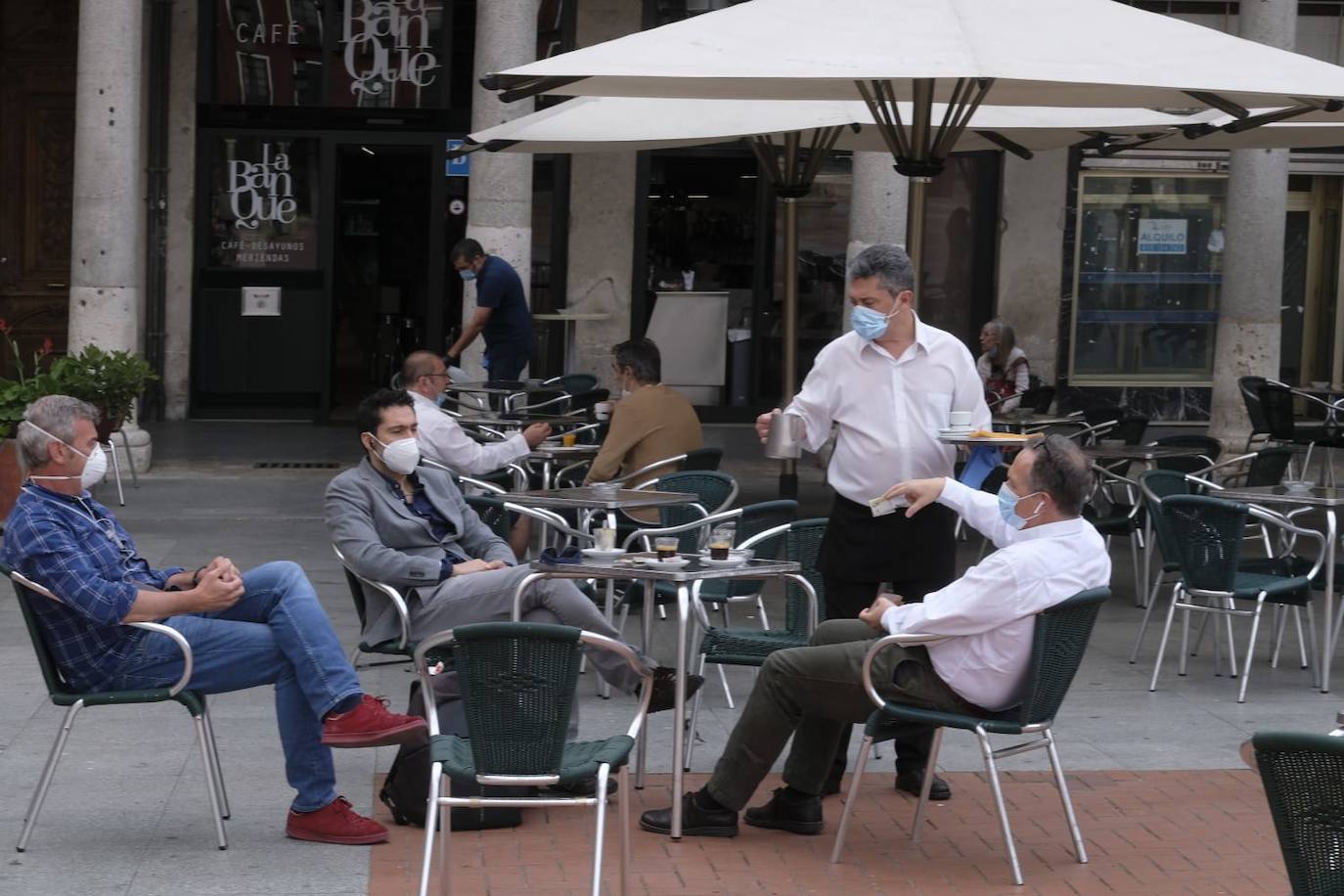 Un camarero sirve a unos clientes en una terraza de la Plaza Mayor 