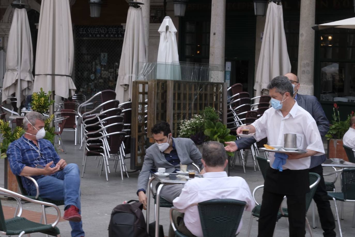 Un camarero sirve a unos clientes en una terraza de la Plaza Mayor 