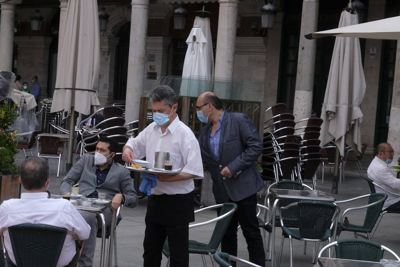 Un camarero sirve a unos clientes en una terraza de la Plaza Mayor 