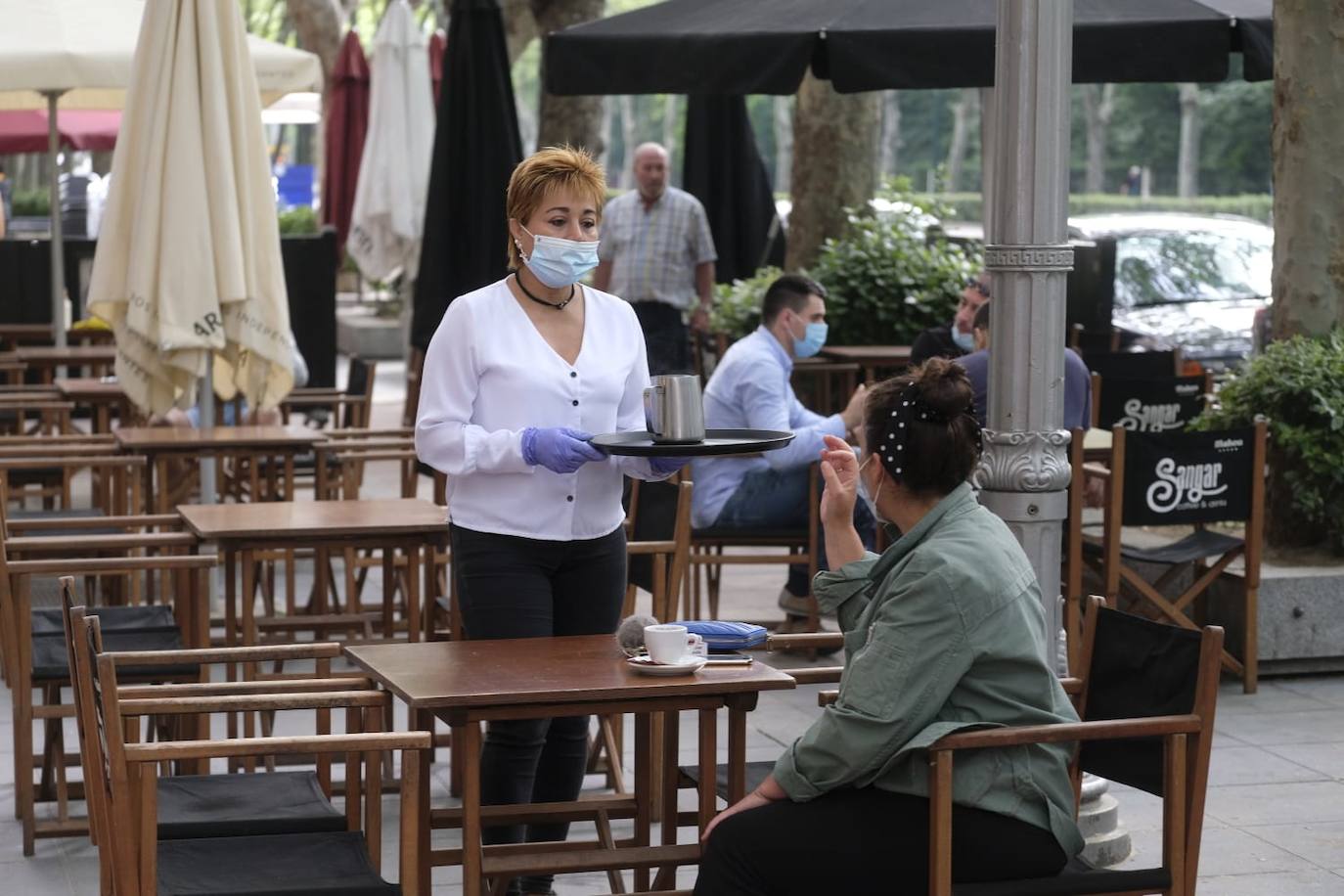 Una camarera atiende a varios clientes en una terraza del Paseo de Zorrilla. 