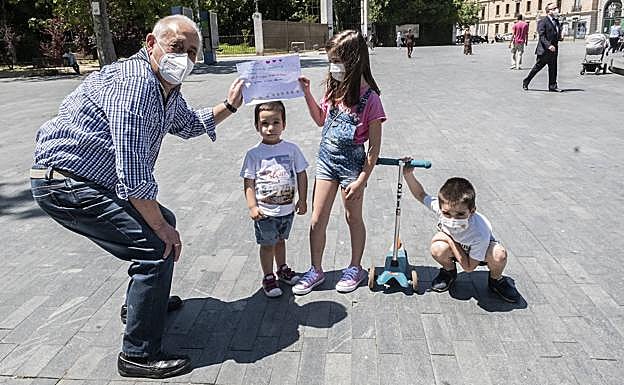 Antonio Olmedo recibe de sus nietos Jorge, Sara y Javier un cartel que le han hecho durante el confinamiento.