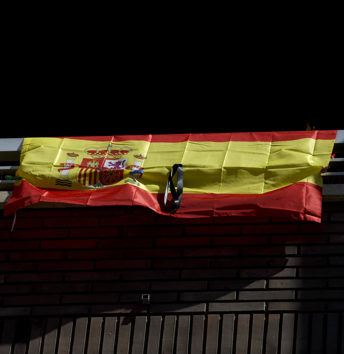 Los vallisoletanos han homenajeado hoy a las víctimas del coronavirus colocando en balcones y ventanas banderas de España y de Castilla y León con crespones negros. 