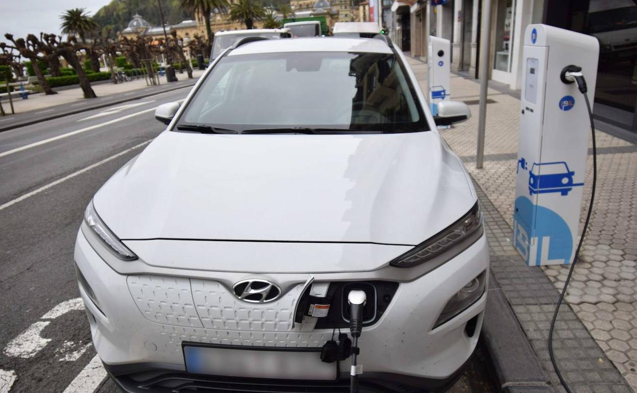 Un coche eléctrico carga su batería en uno de los postes situados en una calle de San Sebastián.