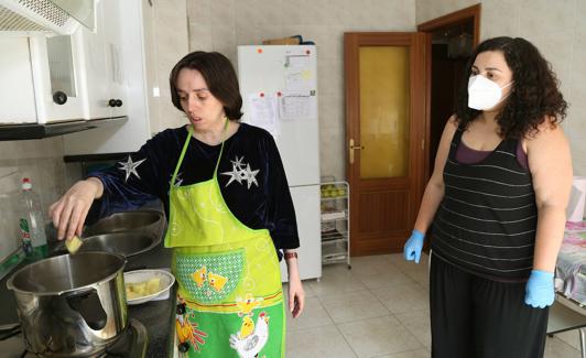 Silvia V. y su asistente personal, María Fraile, preparan la comida en un taller de cocina de la vivienda de Palencia. 